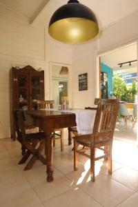 Vila Eco SPA في أراكاجو: غرفة طعام مع طاولة وكراسي خشبية