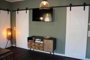 a room with two white doors and a tv on the wall at Ferienwohnung GeestZuhause in Heeslingen