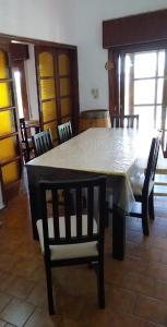 mesa de comedor con sillas y mantel blanco en Vistas de Embalsina en Villa del Dique