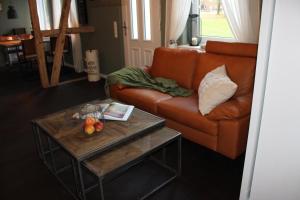 sala de estar con sofá naranja y mesa en Ferienwohnung GeestZuhause en Heeslingen