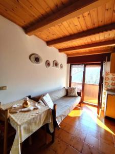 sala de estar con sofá y mesa en Falcade Dolomiti La Quiete Mansarda panoramica, en Fregona