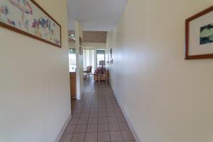 a hallway with white walls and a tile floor at Takanoha Condo in Kahuku