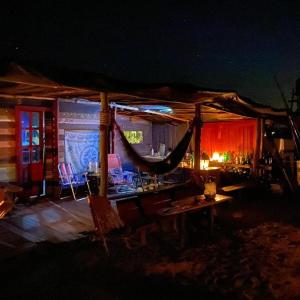 Habitación con hamaca, mesa y sillas. en Calavera Beach Hostel, en Cabo Polonio