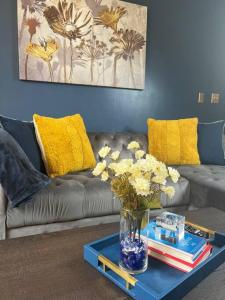 una sala de estar con sofá y un jarrón de flores sobre una mesa en Luxury Midtown Flats near Downtown Memphis & FedEx Forum, en Memphis