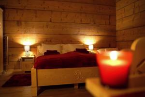 a bedroom with a red bed with two lamps and a candle at Apartamenty u Gąsiorów in Biały Dunajec