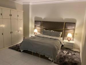 - une chambre avec un grand lit et une grande tête de lit dans l'établissement Nile View 2-Bed Apartment in Zamalek Cairo, au Caire