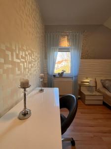 Habitación con escritorio, silla y ventana. en A&D Ferienwohnung Elsasser Blick - Bühlertal bei Bühl, Baden-Baden & Schwarzwald, en Bühlertal 28 fotos más