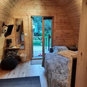 een kamer met een bed in een houten hut bij Log cabin in Kells