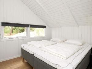 ブラーバンドにあるFour-Bedroom Holiday home in Blåvand 42の窓付きの白い部屋の大型ベッド1台