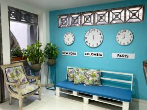 a room with clocks on the wall and a bench at Luna Cartagena Airport Hotel in Cartagena de Indias