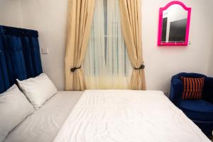 um quarto com uma cama, um espelho e uma cadeira em Discover 8-Bedrooms Lakeside Apartment Living Free WiFi And Well Secured em Amuwo