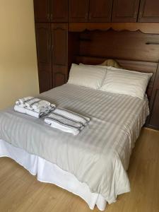 a bed with white sheets and towels on it at Large Townhouse with Gardens in Kingscourt