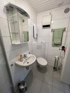 a white bathroom with a sink and a toilet at Ferienwohnung Stefan in Wallertheim