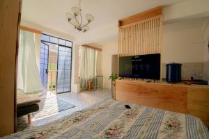 a bedroom with a bed and a tv and a window at Hermoso Loft en el Circulo in Guatemala