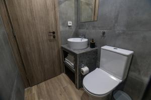 La salle de bains est pourvue de toilettes blanches et d'un lavabo. dans l'établissement Raise Athens Metro Apartments, à Athènes