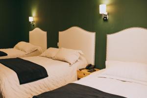 two beds in a room with green walls at Anden Inca Hotel in Cusco