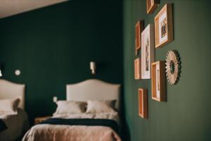 Dormitorio verde con cama y cuadros en la pared en Anden Inca Hotel, en Cusco