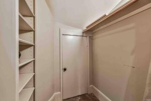 a walk in closet with a door and shelves at Artist's Library with a Private Swimming Pool in Houston +10 photos