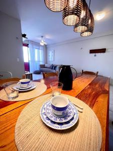 una mesa de madera con platos y cuencos encima en Bessa Beach Inn Ideal para Famílias, en João Pessoa
