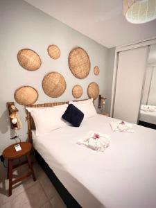 1 dormitorio con 1 cama blanca con cestas en la pared en Bessa Beach Inn Ideal para Famílias, en João Pessoa