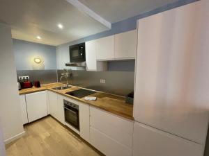 a kitchen with white cabinets and a sink at Studio La Mitre Mourillon à 2 pas des plages in Toulon +7 photos