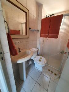 y baño con lavabo, aseo y espejo. en Apartamento em Curitiba completo e perto de tudo, en Curitiba