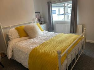 1 dormitorio con 1 cama con manta amarilla y ventana en Beautiful, 1 Bedroom Renovated Cottage en Leicester