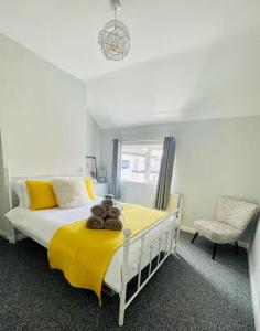Beautiful, 1 Bedroom Renovated Cottage في ليستر: غرفة نوم بسرير وبطانية صفراء وكرسي