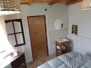 1 dormitorio con cama y baño con espejo. en TERRAZAS de SUMAJ en Maimará