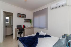 een slaapkamer met een bed, een bureau en een raam bij OFERTA! Ensolarado no 13º andar CENTRAL Próx IMED Garagem in Passo Fundo
