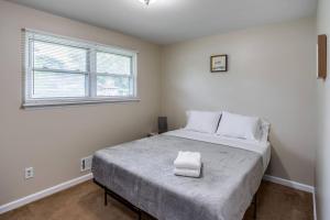 1 dormitorio con 1 cama grande con sábanas blancas en {Quiet Suburban Ranch Hot Tub} Mins Arpt/RIT/DWNT, en Rochester