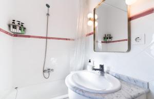 ein weißes Badezimmer mit Waschbecken und Spiegel in der Unterkunft Historic penthouse Plaza Mayor in Madrid in Madrid + 26 Fotos