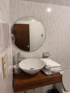 W łazience znajduje się umywalka i lustro. w obiekcie Flores Condominios Casa Narciso w mieście Álamos