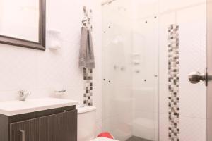 a bathroom with a shower and a toilet and a sink at Vivienda turística Arboleda de Cádiz in Ibagué