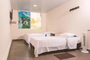 una camera ospedaliera con due letti e un dipinto sul muro di Vivienda turística Arboleda de Cádiz a Ibagué