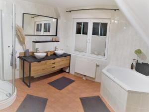 ein Badezimmer mit zwei Waschbecken, einer Badewanne und einer Badewanne in der Unterkunft Haus-Am-See-Pratzschwitz in Pirna