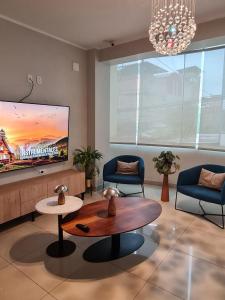 a living room with a tv and a coffee table at Terraza Apart Hotel in Pichanaki