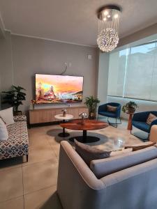 a living room with a couch and a tv on the wall at Terraza Apart Hotel in Pichanaki