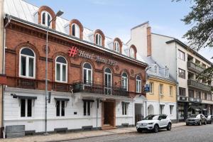 een witte auto geparkeerd voor een gebouw bij Best Western Hotel Anno 1937 in Kristianstad