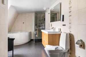 克里斯蒂安斯塔德的住宿－貝斯特韋斯特安諾1937酒店，浴室配有卫生间、盥洗盆和浴缸。