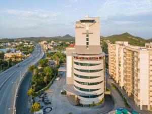 a building with a clock tower next to a road at Radisson Hotel Nathdwara in Nāthdwāra