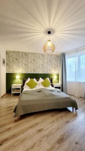 um quarto com uma cama grande e almofadas amarelas em DN Green apartment em Budapeste