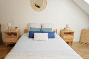 um quarto com uma cama com almofadas azuis e um espelho em Studio proche centre ville em Le Mans