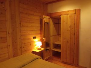 a bedroom with a bed and a lamp and a closet at Albergo Martinet in Vernante