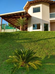 a palm tree in front of a house at Sitio Lugar de Descanso em Lagoa Santa in Jaboticatubas