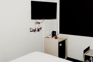 a room with a bed and a television on the wall at Nightcap at Barkly Hotel in Mount Isa