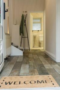 a bathroom with a welcome mat on the floor at Elegant three bed bungalow in Lincolnshire