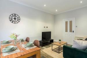 a living room with a table and a tv at Elegant three bed bungalow in Lincolnshire