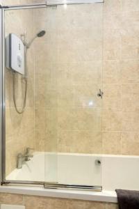 a bathroom with a shower with a glass door at Elegant three bed bungalow in Lincolnshire