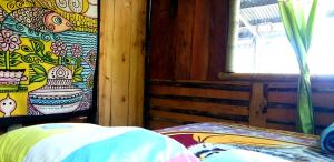 een slaapkamer met een schilderij aan de muur en een raam bij Roots in Valle Hornito